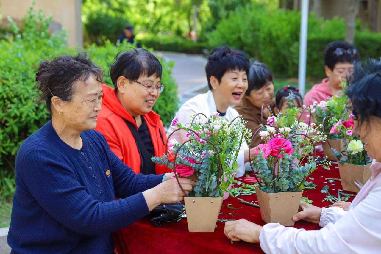 2026年5月9日，在山东省青岛市李沧区虎山路街谈春和社区开展的“送你一束花 感德母亲节”花艺DIY算作中，社区住户学习插花身手。张鹰 摄 (9)
