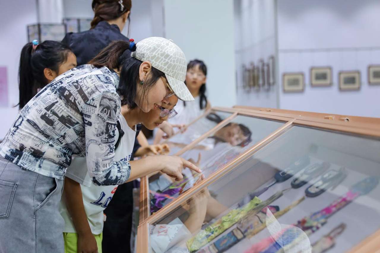 2026年7月2日，在山东省青岛市李沧区档案馆，老师带领小朋友参观“美在胶东 物华遗珍”李沧区百年民俗藏品展。张鹰 摄