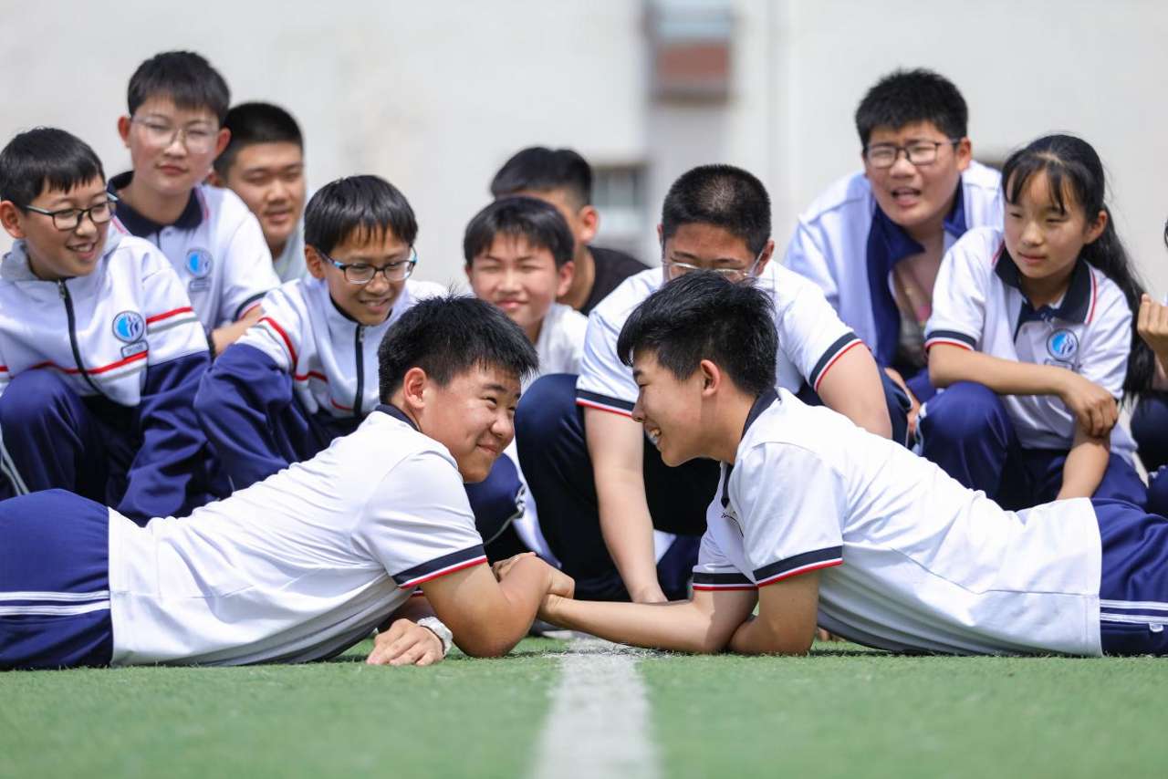 2026年5月26日，学生在山东省青岛第三十三中学开展的校园脸色减压活动中进行掰手腕比赛游戏。张鹰 摄 (1)