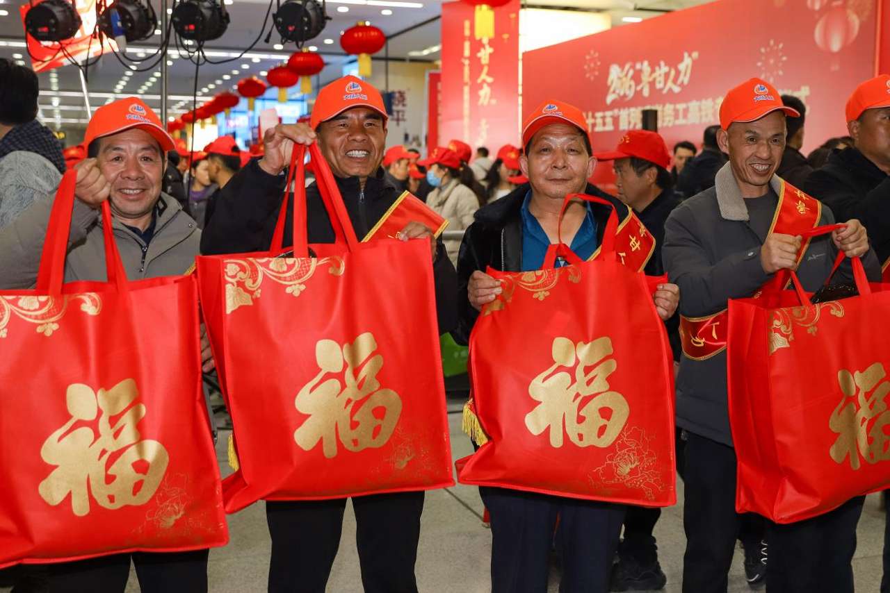 2026年2月25日晚，在山东青岛北站举行的2026“鲁甘东谈主力”青岛·定西“十五五”首列返岗务工高铁专列迎接庆典上，来自甘肃的务工东谈主员展示领取的大礼包。张鹰 摄